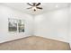 Spacious bedroom with plush carpeting, a ceiling fan, and a large window offering ample natural light at 3444 Underwood Se Ct, Conyers, GA 30013