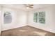 Bright bedroom features a ceiling fan and two windows offering views of the wooded surroundings at 3444 Underwood Se Ct, Conyers, GA 30013