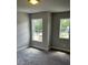Carpeted bedroom features natural light and views from the dual windows with neutral colored walls at 4180 Cavalier Way, Duluth, GA 30097