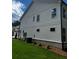 Side view of the townhome showing the white siding and brick foundation at 4180 Cavalier Way, Duluth, GA 30097