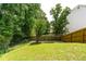 Green backyard featuring a mix of grass and trees enclosed by a wood and chain-link fence at 4613 Creek Forest Ct, Lilburn, GA 30047