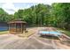 Community sports court with table tennis, basketball, and seating area surrounded by trees at 4613 Creek Forest Ct, Lilburn, GA 30047