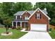Charming brick home featuring a covered front porch and well-manicured lawn at 4613 Creek Forest Ct, Lilburn, GA 30047