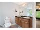 Bathroom with dual sink vanity, toilet, and view to bedroom at 5427 Highway 81, Loganville, GA 30052