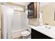 Cozy bathroom featuring a shower-tub, a vanity with storage, and an overhead cabinet at 5427 Highway 81, Loganville, GA 30052
