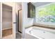 Bathroom with soaking tub, walk-in shower, decorative window, and closet at 5427 Highway 81, Loganville, GA 30052
