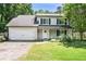 Charming two-story home featuring a front yard, attached garage, and traditional architectural details at 5427 Highway 81, Loganville, GA 30052