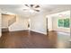 Open-concept living room with hardwood floors, staircase, ceiling fan, and natural light at 5427 Highway 81, Loganville, GA 30052