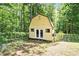 Yellow shed exterior with double doors and a wood fence at 5427 Highway 81, Loganville, GA 30052