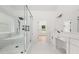 Bathroom with glass shower, tub, double vanity, and white marble tile flooring at 2339 Eastwood Dr, Snellville, GA 30078