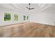 Bright bedroom with tray ceiling, ceiling fan, large windows, and wood flooring at 2339 Eastwood Dr, Snellville, GA 30078
