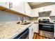 Close-up of a kitchen with stainless steel appliances, granite countertops, and wood flooring at 3626 Buford Ne Hwy # C2, Brookhaven, GA 30329