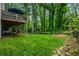 A lush backyard features a deck, lawn, and wooded surroundings for privacy and outdoor enjoyment at 6119 Fairlong Nw Run, Acworth, GA 30101