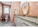 Charming bathroom with pink daisy wallpaper, granite countertop, and gold-trimmed mirror at 6119 Fairlong Nw Run, Acworth, GA 30101
