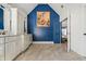 Spacious bathroom with double vanities, white cabinets, blue accent wall with an artistic floral display at 6119 Fairlong Nw Run, Acworth, GA 30101