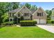 Charming two-story brick home with attached two-car garage, manicured lawn, and mature landscaping at 6119 Fairlong Nw Run, Acworth, GA 30101