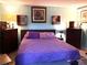 Spacious bedroom featuring a plush purple bed, soft carpet, and lots of dresser top decor at 9400 Roberts Dr # 7M, Atlanta, GA 30350