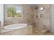 Elegant bathroom with a soaking tub and a separate shower with beige stone at 13090 Magnolia Crescent Dr, Roswell, GA 30075