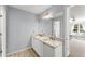 Bathroom featuring double sinks, granite countertops, and white cabinetry creating a bright and modern space at 13090 Magnolia Crescent Dr, Roswell, GA 30075