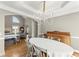 Formal dining room with hardwood floors, a chandelier, and views of the living area at 13090 Magnolia Crescent Dr, Roswell, GA 30075