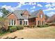 Beautiful brick home featuring a manicured lawn and mature trees, exuding classic charm and elegance at 13090 Magnolia Crescent Dr, Roswell, GA 30075