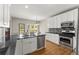 Modern kitchen with stainless steel appliances, granite countertops, and white cabinets at 13090 Magnolia Crescent Dr, Roswell, GA 30075