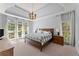 Tranquil primary bedroom with tray ceilings, large windows and ensuite bathroom at 13090 Magnolia Crescent Dr, Roswell, GA 30075