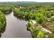 Aerial view of waterfront amenities including a pool and tennis courts surrounded by mature trees at 4052 Loch Highland Ne Pass, Roswell, GA 30075