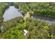 Stunning aerial view showcasing the home nestled within lush trees, situated next to a tranquil lake at 4052 Loch Highland Ne Pass, Roswell, GA 30075