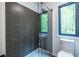 Bathroom with a glass shower, gray tile, and a window showcasing a lush view at 4052 Loch Highland Ne Pass, Roswell, GA 30075