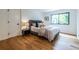 Cozy bedroom with a plush bed, hardwood floors, and a bright window at 4052 Loch Highland Ne Pass, Roswell, GA 30075