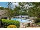A community pool is surrounded by lush greenery and overlooks a serene lake, a spot for relaxation at 4052 Loch Highland Ne Pass, Roswell, GA 30075