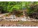Beautifully landscaped grounds with custom waterfalls and lush greenery and colorful flowers at 4052 Loch Highland Ne Pass, Roswell, GA 30075