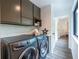Well-organized laundry room featuring a modern washer and dryer and sleek, dark cabinetry at 4052 Loch Highland Ne Pass, Roswell, GA 30075
