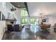 Spacious living room with a stone fireplace, high ceilings, and floor-to-ceiling windows overlooking lush greenery at 4052 Loch Highland Ne Pass, Roswell, GA 30075