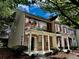 Brick townhouse showcasing a covered front porch, complemented by mature trees and landscaping at 4842 Hairston Park Sq, Stone Mountain, GA 30083