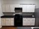 Functional kitchen featuring white cabinets, black appliances and countertops at 4842 Hairston Park Sq, Stone Mountain, GA 30083