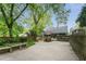 Expansive brick-paved backyard with a deck, red umbrella, and lush greenery, offering ample space for outdoor activities at 541 Greenwood Ne Ave, Atlanta, GA 30308
