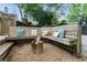 This backyard seating area includes a wooden bench with colorful pillows and a modern fire pit for outdoor enjoyment at 541 Greenwood Ne Ave, Atlanta, GA 30308