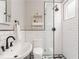 Modern bathroom with subway tile, black fixtures, glass-enclosed shower, and decorative mosaic tile flooring at 541 Greenwood Ne Ave, Atlanta, GA 30308