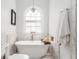 Bright bathroom featuring a luxurious soaking tub, marble tiling, arched window and modern fixtures at 541 Greenwood Ne Ave, Atlanta, GA 30308