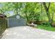 Paved driveway leads to a detached green garage with a unique round window and garden beds along the side at 541 Greenwood Ne Ave, Atlanta, GA 30308
