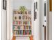 Hallway featuring a built-in bookshelf filled with books, artwork, and hardwood floors at 541 Greenwood Ne Ave, Atlanta, GA 30308