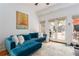 Comfortable living area with plush blue sofa, neutral rug and bright light entering through the French doors at 541 Greenwood Ne Ave, Atlanta, GA 30308
