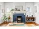 Close-up on a cozy living room with a fireplace, mantel with decor, and warm wood floors at 541 Greenwood Ne Ave, Atlanta, GA 30308