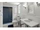 Bright bathroom featuring a blue tiled shower, white fixtures, and coordinated decor at 675 W Paces Ferry Nw Rd # 11, Atlanta, GA 30327