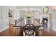 Grand dining room boasts a long wooden table, chandelier, and fireplace, perfect for entertaining guests at 675 W Paces Ferry Nw Rd # 11, Atlanta, GA 30327