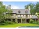 Back of Tudor home with balcony, covered patio, green lawn and inground pool and hot tub at 675 W Paces Ferry Nw Rd # 11, Atlanta, GA 30327