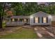 Charming single-story home with a covered porch, gray siding, and driveway leading to the house at 7845 Chase Woods Dr, Jonesboro, GA 30236