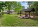 Spacious backyard showcasing a well-manicured lawn, a cozy gazebo, and a fire pit area for outdoor enjoyment at 206 Flora Ne Ave, Atlanta, GA 30307
